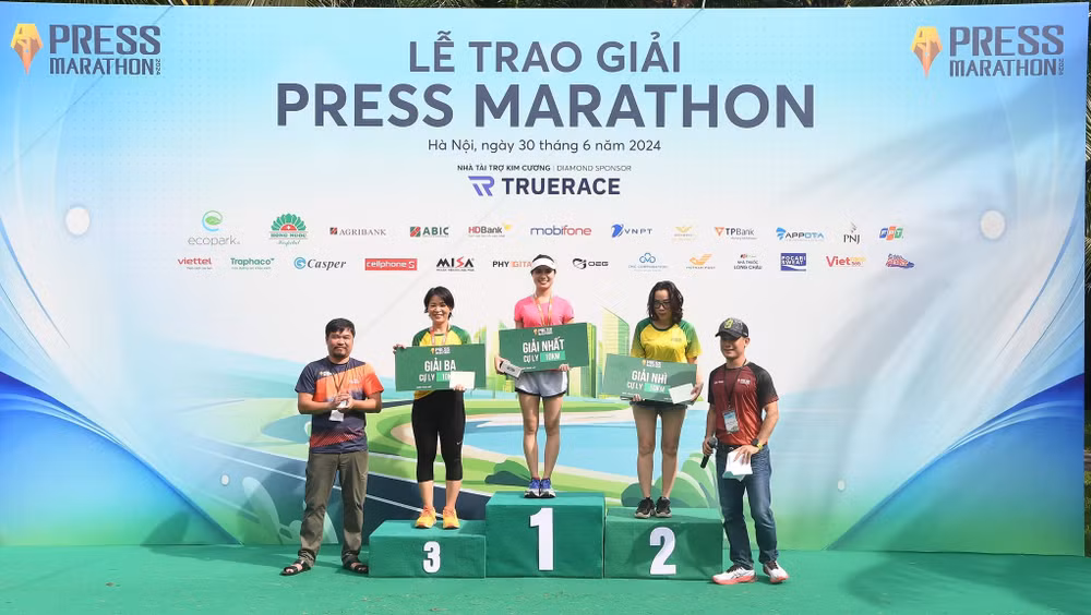 Nhà báo Đỗ Như Yến trên bục nhận giải Nhất cự ly 10km nữ. (Ảnh: TRUNG HƯNG)