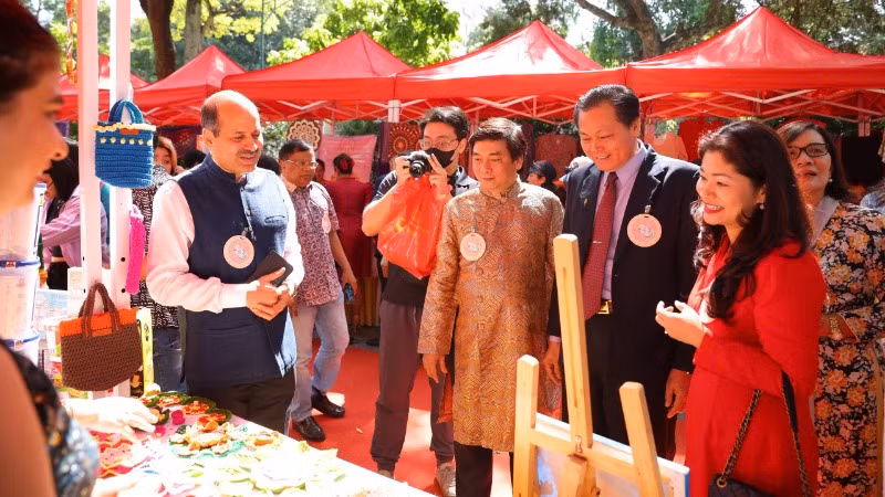 Đại sứ Ấn Độ Sandeep Arya và phu nhân hướng dẫn khách tham quan các gian hàng trong khuôn khổ hội chợ. 