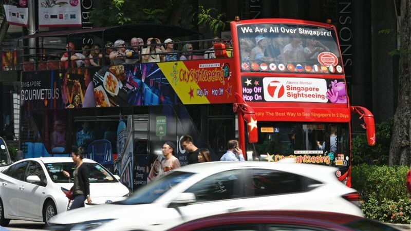 Xe buýt chở khách du lịch trên đường phố Singapore. (Ảnh: Xinhua)