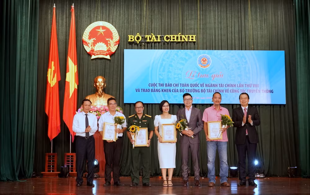 Thứ trưởng Tài chính Nguyễn Đức Chi và Phó Chủ tịch Thường trực Hội Nhà báo Việt Nam Nguyễn Đức Lợi trao giải A cho các tác giả và đại diện nhóm tác giả đoạt giải. (Ảnh: TRUNG HƯNG)