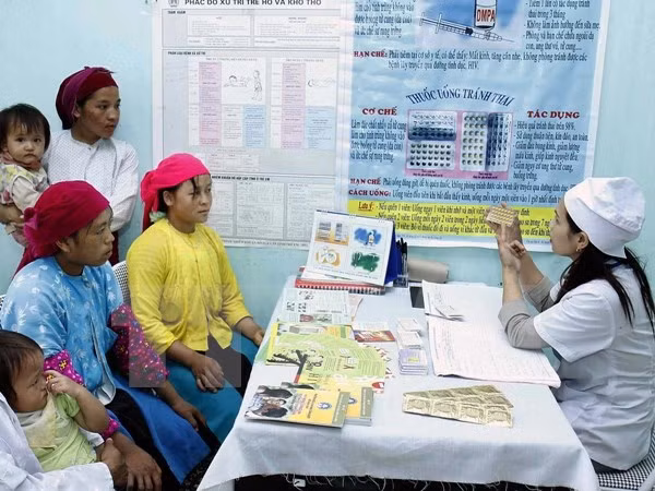 Cán bộ y tế tư vấn chăm sóc sức khỏe sinh sản cho chị em phụ nữ vùng cao. (Ảnh: TTXVN)