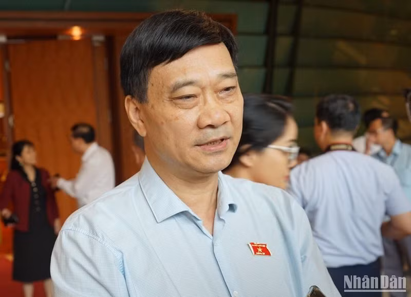 Ủy viên Ủy ban Thường vụ Quốc hội, Chủ nhiệm Ủy ban Kinh tế của Quốc hội Vũ Hồng Thanh chia sẻ với phóng viên bên hành lang Quốc hội sáng 24/6. (Ảnh: TRUNG HƯNG)