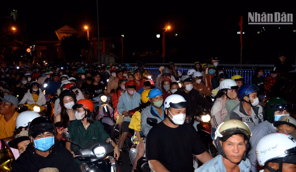 Dòng người đổ về các điểm tập trung 2 bên bờ sông Cà Ty để xem bắn pháo hoa tầm thấp.