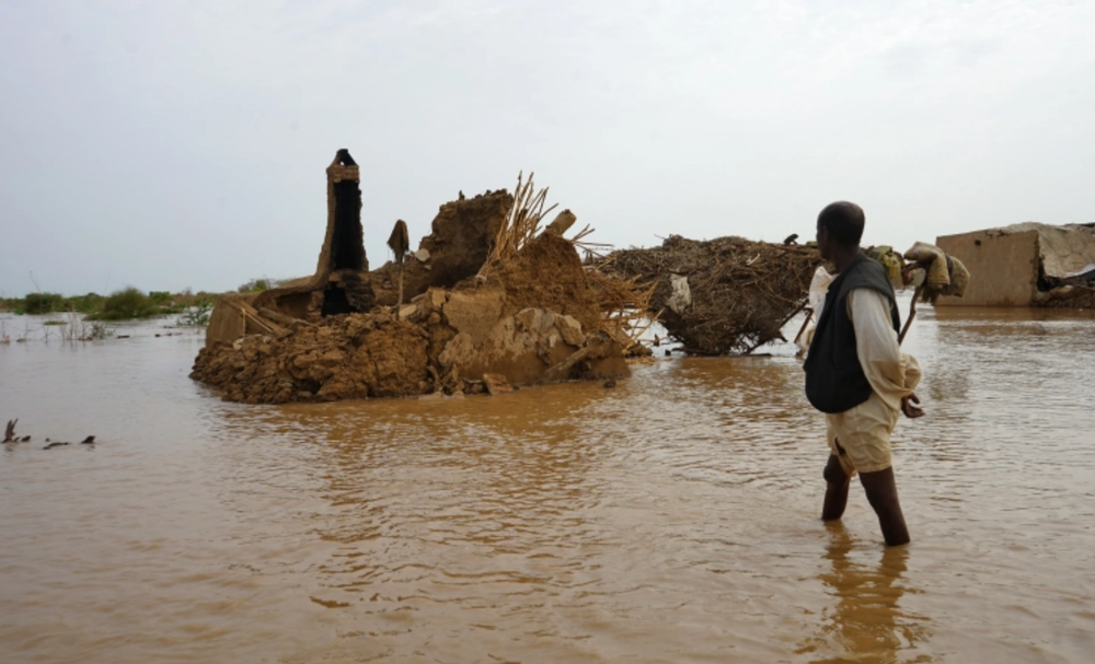 Một người dân lội qua khu vực bị ngập lụt ở Kassala, Sudan, ngày 18/8/2022. (Ảnh: AFP)
