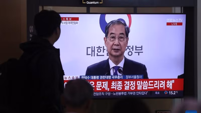 Người dân theo dõi bài phát biểu của ông Han Duck Soo tại ga tàu Seoul, ngày 1/5/2025. (Ảnh: Xinhua)