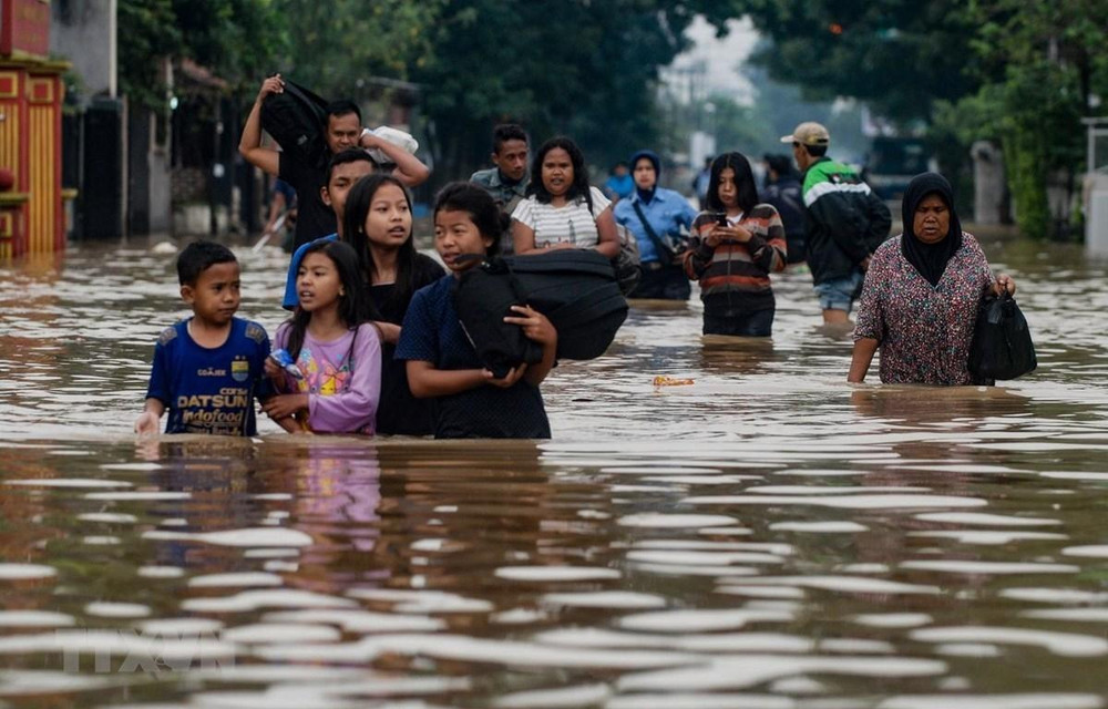 Sơ tán người dân khỏi khu vực ngập lụt tại Indonesia. (Ảnh: AFP/TTXVN)