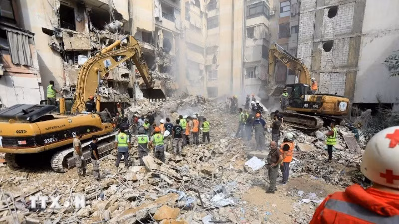 Lực lượng cứu hộ dọn dẹp đống đổ nát sau cuộc tập kích của Israel tại Beirut, Liban. (Ảnh: THX/TTXVN)