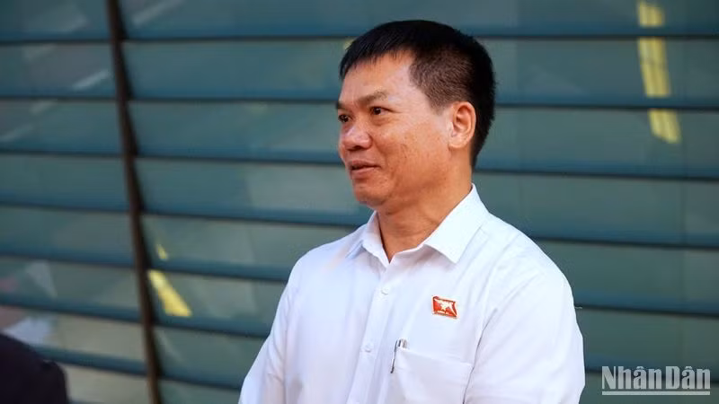 Đại biểu Dương Khắc Mai (Đoàn đại biểu Quốc hội tỉnh Đắc Nông) trao đổi bên hành lang Quốc hội. (Ảnh: TRUNG HƯNG)