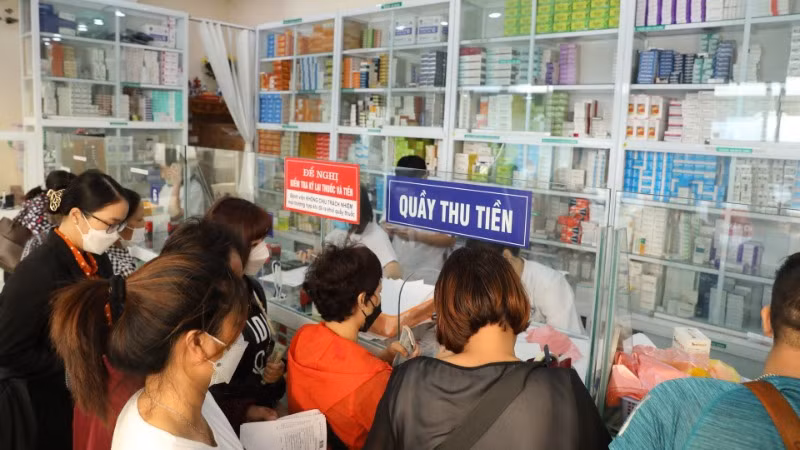 Bệnh nhân xếp hàng chờ mua thuốc tại bệnh viện. (Ảnh: TTXVN)