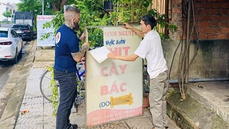 Người dân Hội An tháo dỡ biển hiệu sau khi thực hiện cam kết chấm dứt việc buôn bán thịt chó, mèo. (Ảnh: FOUR PAWS)