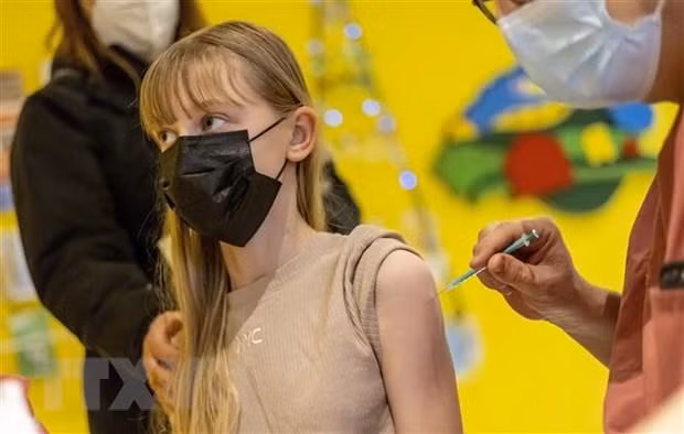 Nhân viên y tế tiêm vaccine ngừa Covid-19 cho người dân tại Berlin, Đức. (Ảnh: AFP/TTXVN)