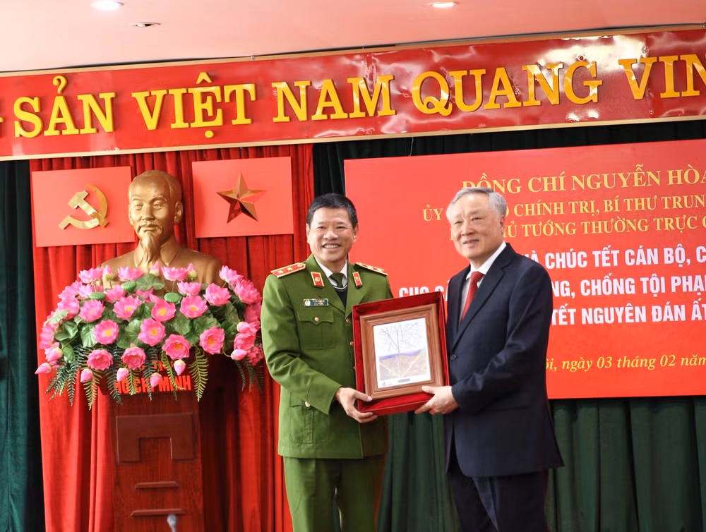 Trung tướng Trần Minh Lệ, Cục trưởng Cục Cảnh sát phòng, chống tội phạm về môi trường trao tặng Phó Thủ tướng Thường trực Chính phủ Nguyễn Hòa Bình bức tranh lưu niệm về bảo vệ môi trường. (Ảnh: TÂM PHẠM)