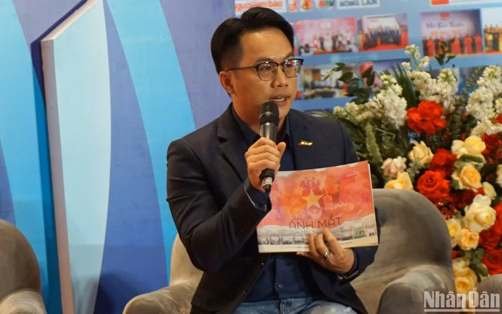 Nhà báo Võ Huỳnh Tấn Tài và cuốn kỷ yếu đặc biệt tại tọa đàm. (Ảnh: TRUNG HƯNG)