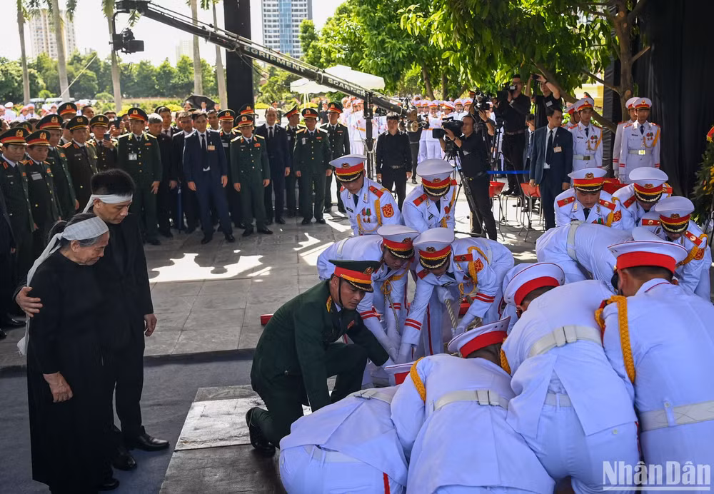 Gia đình cùng các đại biểu chứng kiến Đội nghi lễ tiến hành hạ huyệt linh cữu Tổng Bí thư Nguyễn Phú Trọng.