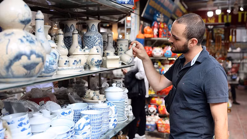 Du khách nước ngoài tham quan, mua sắm tại làng gốm Bát Tràng, huyện Gia Lâm (Hà Nội). (Ảnh TUỆ NGHI)