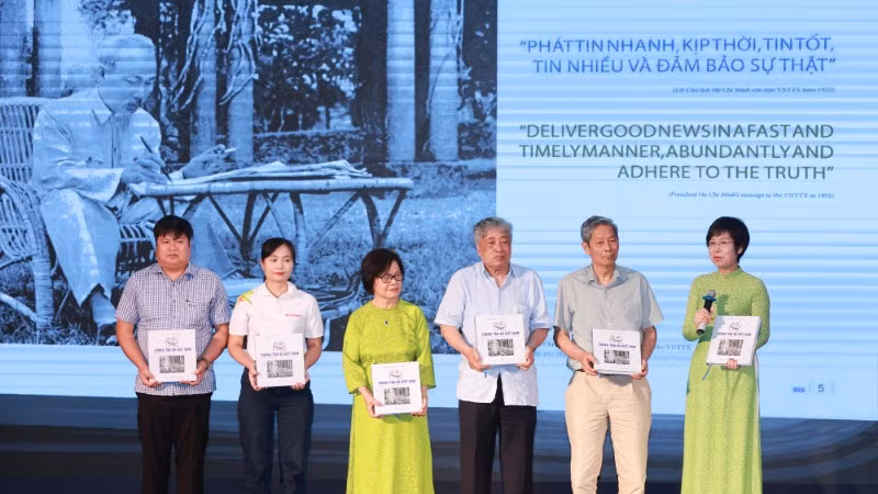 Tổng Giám đốc Thông tấn xã Việt Nam Vũ Việt Trang trao tặng cuốn sách cho các khách mời tham dự tọa đàm “Viết tiếp bản hùng ca.” (Ảnh: Hoài Nam/Vietnam+)