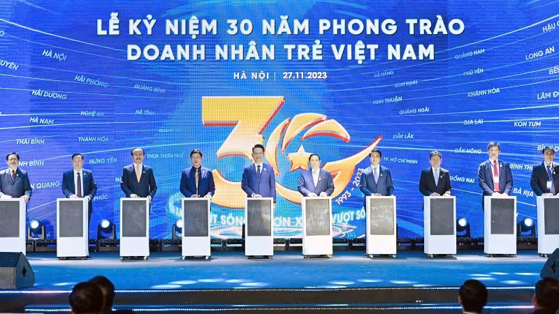 Thủ tướng Phạm Minh Chính (thứ 5 từ phải qua) cùng đại diện Hội Doanh nhân trẻ Việt Nam và các đơn vị liên quan tại Lễ kỷ niệm 30 năm phong trào Doanh nhân trẻ Việt Nam.