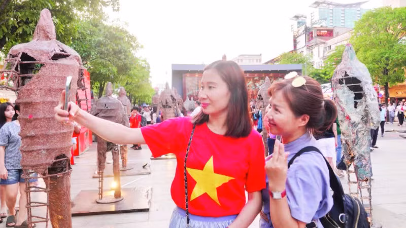 Du khách thích thú với các hoạt động trong chuỗi sự kiện “Sắc màu thành phố Bác” tại đường đi bộ Nguyễn Huệ. (Ảnh MẠNH HẢO)