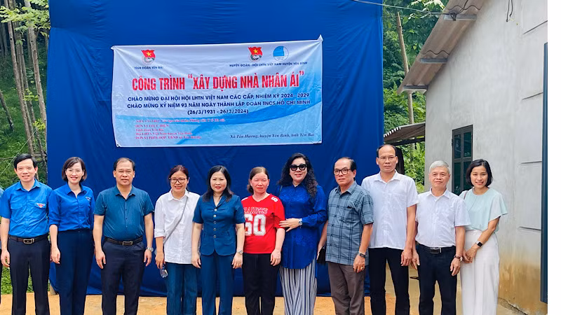 Nhóm tài trợ chụp ảnh bên ngôi nhà mới được xây dựng. (Ảnh: THANH SƠN)