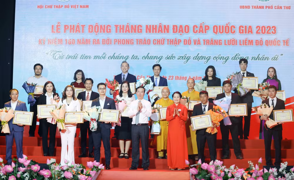 Chủ tịch nước Võ Văn Thưởng, Chủ tịch danh dự Hội Chữ thập Đỏ Việt Nam và bà Bùi Thị Hòa, Chủ tịch Hội Chữ thập Đỏ Việt Nam tặng hoa và trao bảng Ghi nhận tấm lòng vàng nhân đạo. (Ảnh: TTXVN) 