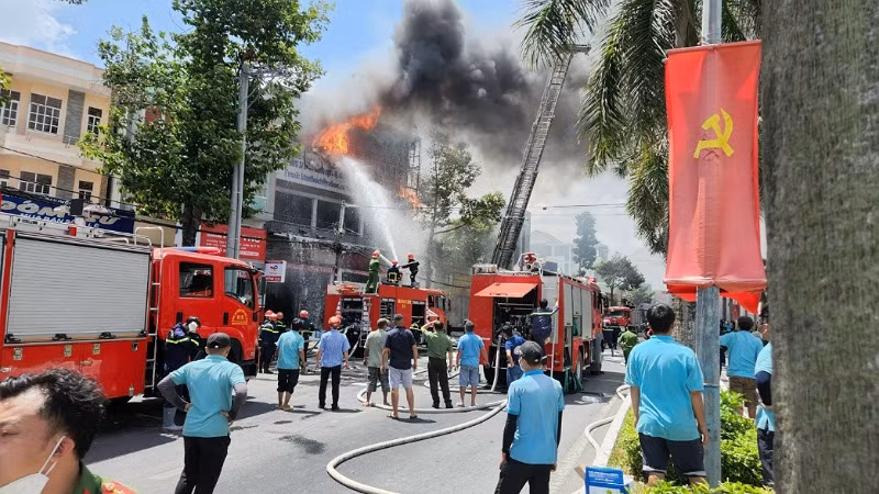 Những người thợ (áo xanh) đang làm việc tại garage Kim Thu kịp thời chạy ra khỏi khu nhà xưởng bị cháy.