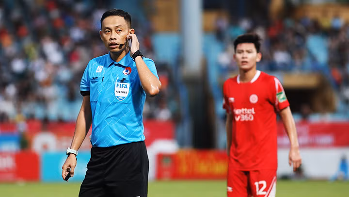 Trọng tài chính tham khảo trọng tài VAR trong một trận đấu tại V.League. Ảnh: LÊ MINH