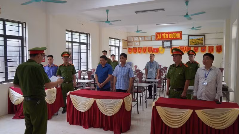 Cơ quan cảnh sát điều tra thi hành quyết định khởi tố đối với hai lãnh đạo xã Yến Dương. (Ảnh: THUỲ DƯƠNG).