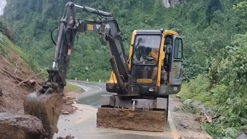 Hót dọn đất, đá sạt lở trên Quốc lộ 3B. (Ảnh: CÔNG LUẬN).