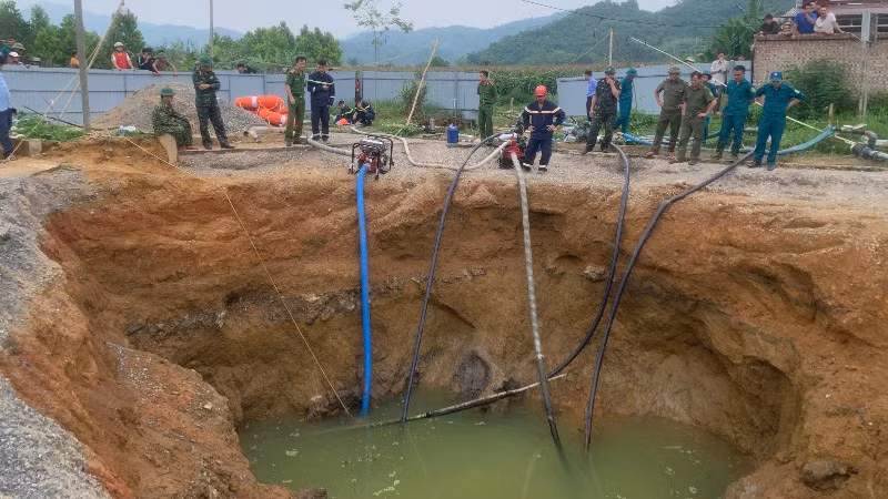 Dùng máy bơm hút nước để tìm kiếm nạn nhân. (Ảnh: TUẤN SƠN)