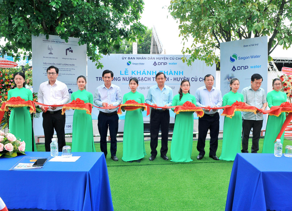 Đại diện ban lãnh đạo huyện Củ Chi và các nhà tài trợ cùng cắt băng khánh thành trụ nước uống sạch cộng đồng.
