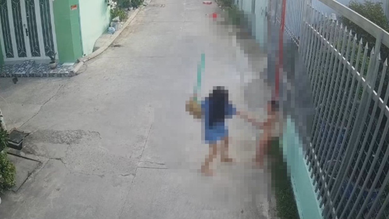 Bà Trang dùng chổi đánh cháu T. (Ảnh cắt từ camera)