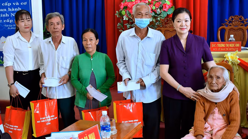 Bà Trương Thị Ngọc Ánh (áo tím) tặng quà các gia đình chính sách huyện Trần Văn Thời.