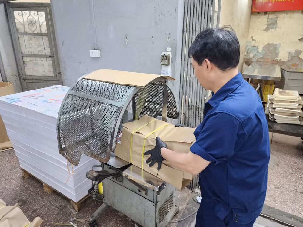 Công nhân nhà in Báo Nhân Dân đóng gói ấn phẩm phụ san đặc biệt kỷ niệm 50 năm Ngày Giải phóng miền nam, thống nhất đất nước giao tới bạn đọc