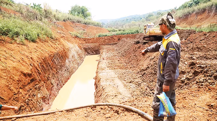 Gia đình anh Y Oen Niê ở buôn Ea Káp, xã Ea Sin, huyện Krông Búk cùng các hộ dân góp tiền thuê xe múc về múc hồ dưới lòng hồ đã khô cạn để tìm nước cứu cây trồng.