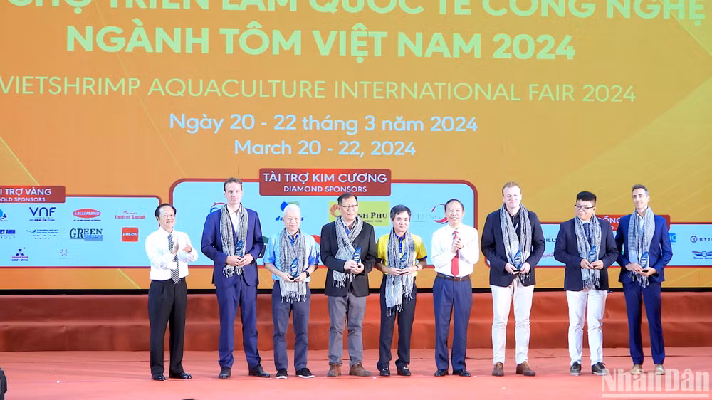 Thứ trưởng Nông nghiệp và Phát triển nông thôn Phùng Đức Tiến (cà vạt đỏ) tham quan không gian trưng bày sản phẩm ngành tôm tại hội chợ triển lãm.