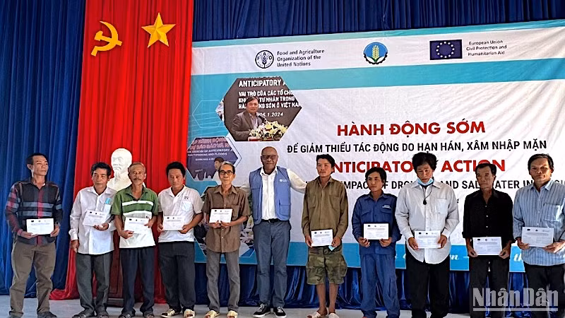 Đại diện tổ chức FAO tại Việt Nam trao hỗ trợ bằng tiền mặt cho người dân chịu ảnh hưởng bởi hạn-mặn tại Cà Mau.