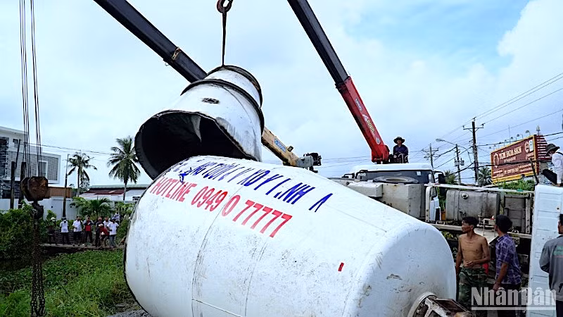 Lực lượng làm nhiệm vụ cắt thùng bê-tông để giải cứu chiếc xe lật nằm chắn ngang tuyến Quốc lộ 63. 