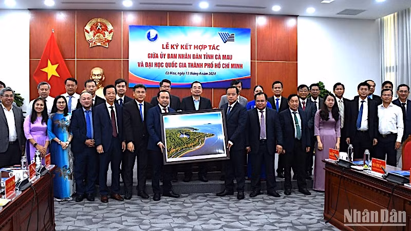 Lãnh đạo tỉnh Cà Mau tặng quà và chụp ảnh lưu niệm với đại diện Đại học Quốc gia Thành phố Hồ Chí Minh tại lễ ký kết.