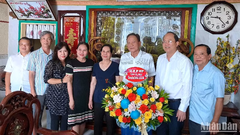 Bí thư Tỉnh ủy Cà Mau Nguyễn Hồ Hải (đeo kính) cùng đoàn công tác chụp ảnh lưu niệm tại gia đình Bác sĩ Nhan Văn Đấu, nguyên Giám đốc Bệnh viện đa khoa Cà Mau.