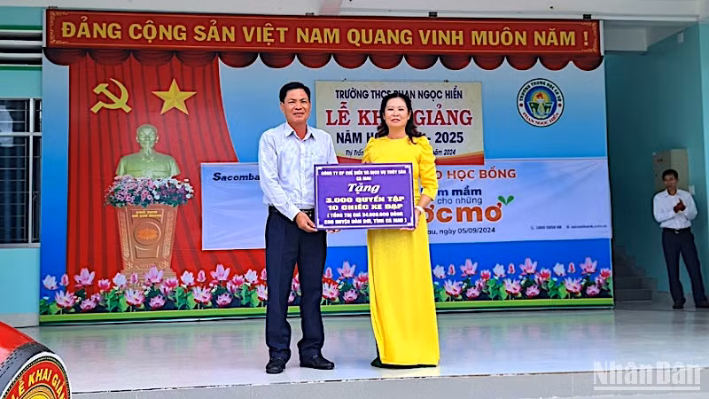 Đại diện chính quyền địa phương và đơn vị trường học tại huyện Đầm Dơi tiếp nhận hỗ trợ xe đạp và tập học sinh được vận động từ Báo Nhân Dân.