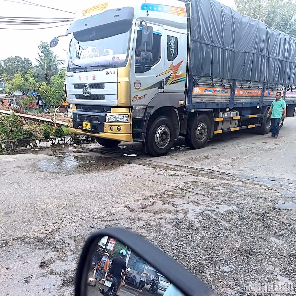 Xe quá tải của tài xế tỉnh Quảng Ngãi bị tạm giữ tại một vị trí gần cầu dân sinh bị hư hỏng.