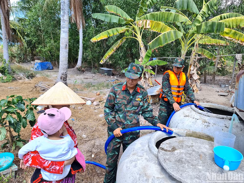 Lực lượng chuyên trách của Quân khu 9 vận chuyển nước sinh hoạt đến tận nhà cho hộ dân xã Biển Bạch (huyện Thới Bình, tỉnh Cà Mau).