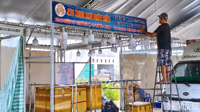 Tiểu thương tham gia hội chợ trang trí biển hiệu để chuẩn bị bố trí hàng hóa phục vụ hội chợ tại miền biển Sông Đốc.