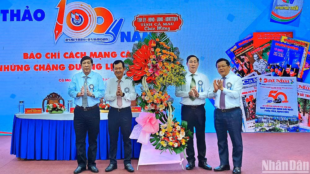 Phó bí thư Thường trực Tỉnh ủy Cà Mau Nguyễn Đức Hiển (bìa phải) tặng hoa chúc mừng tại hội thảo.