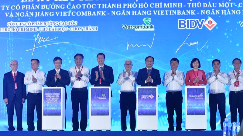 Lãnh đạo tỉnh Bình Dương chứng kiến nghi thức ký thỏa thuận tín dụng tài trợ cho dự án cao tốc. (Ảnh: THANH GIANG)