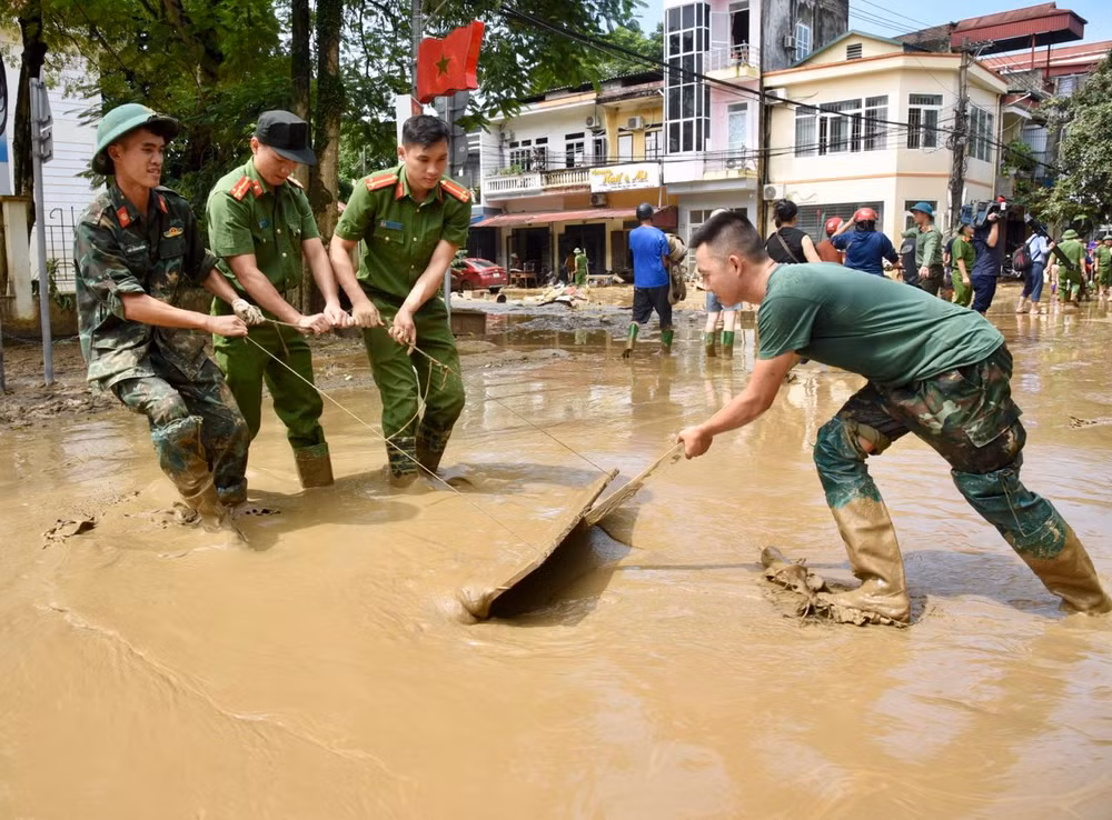 Các lực lượng quân đội và công an giúp nhân dân dọn dẹp vệ sinh môi trường sau bão lũ tại thành phố Yên Bái (Ảnh: TRẦN HẢI). 