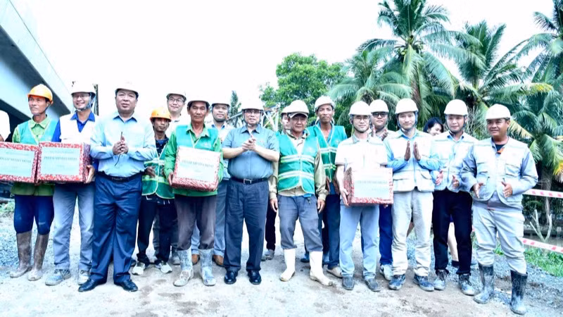 Thủ tướng Phạm Minh Chính tặng quà động viên đội ngũ kỹ sư, công nhân đang thi công tại Nút giao IC4 thuộc Dự án cao tốc Cần Thơ-Cà Mau. (Ảnh: Thanh Giang)