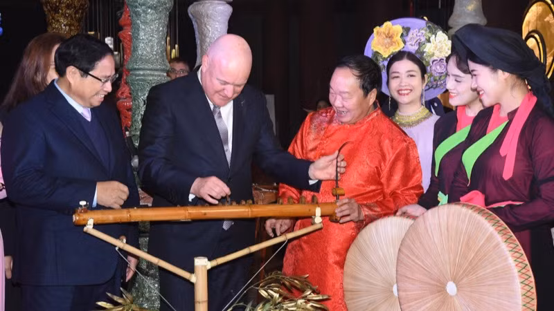 Thủ tướng New Zealand Christopher Luxon trải nghiệm nhạc cụ đàn bầu làm bằng thân tre. (Ảnh: TRẦN HẢI)