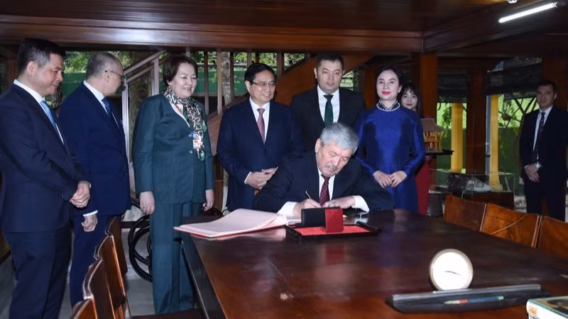 Thủ tướng Kyrgzystan Adylbek Kasymaliev viết lưu bút tại Nhà sàn Bác Hồ.