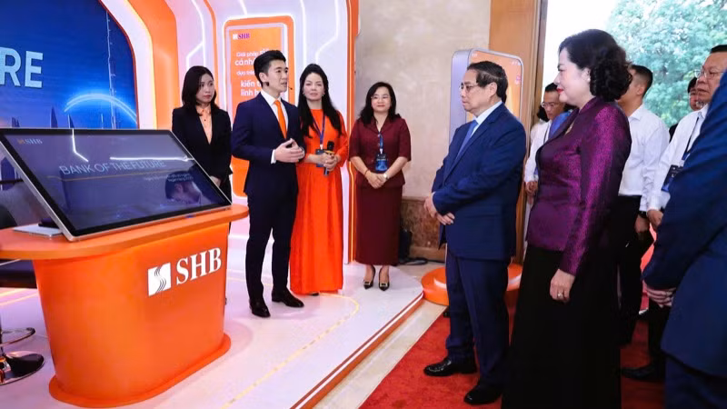 Lãnh đạo Ngân hàng SHB giới thiệu với Thủ tướng Phạm Minh Chính về những dịch vụ, tiện ích thông minh của ngân hàng. (Ảnh: TRẦN HẢI)